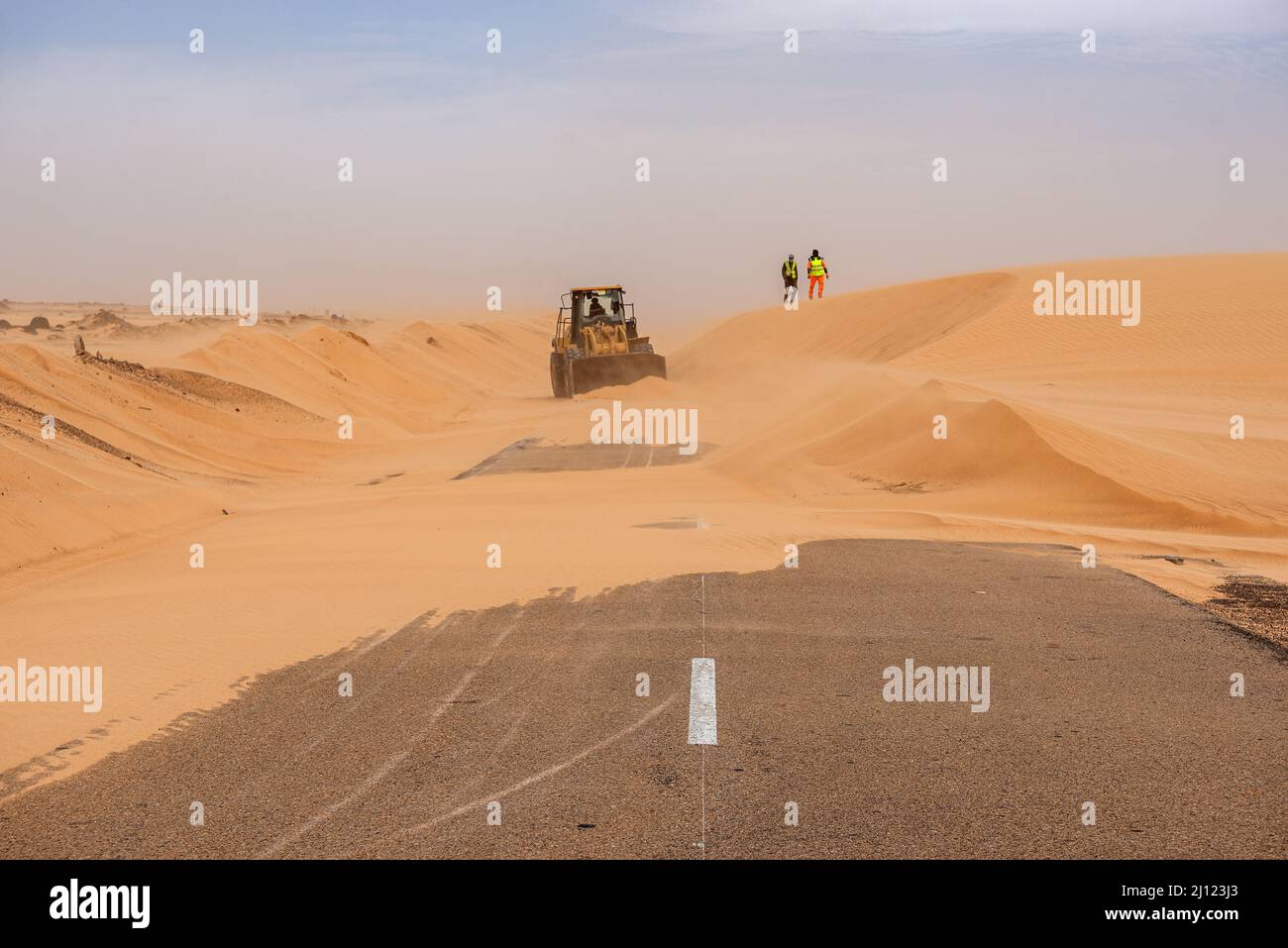 Ein Bulldozer arbeitet, um Wüstensand von der Straße zu entfernen, Adrar Region, Mauretanien Stockfoto
