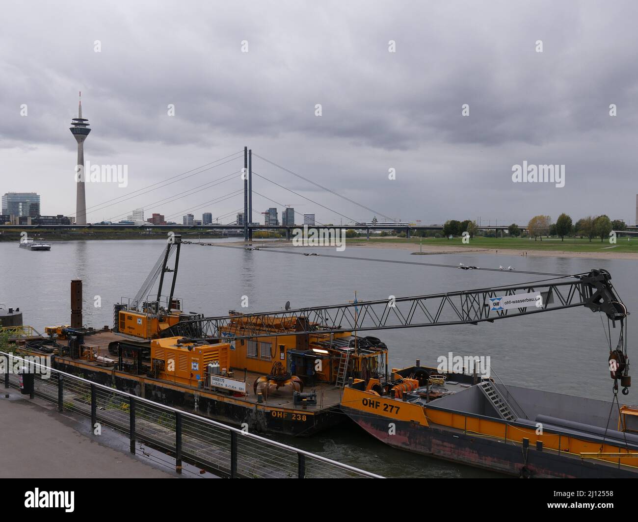 Düsseldorf, Deutschland 11,3.2019, 4,04 Uhr Blick auf den Rhein, ein oder-ange-farbiger Arbeitsschiff, der mit einem Kran an der Bank befestigt ist Stockfoto