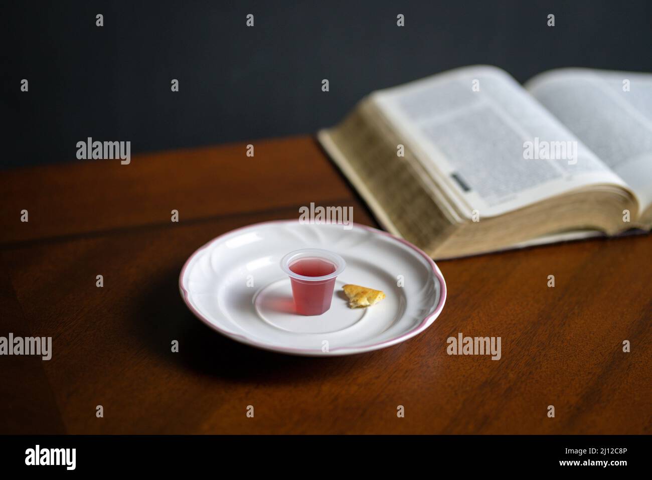Christliches Abendmahl Sakramente, Wein und Brot mit der Heiligen Bibel im Hintergrund. Stockfoto