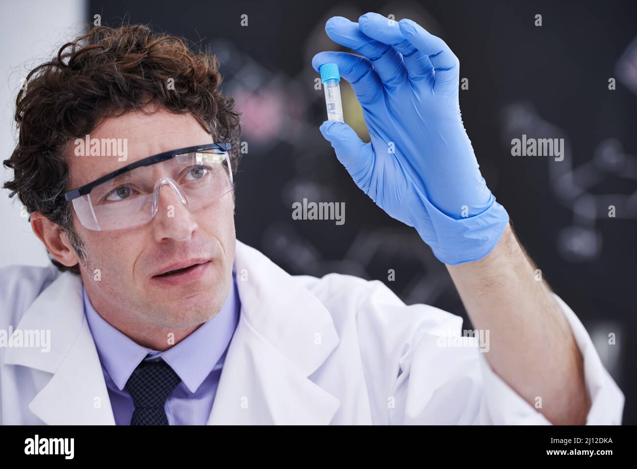 Die Zukunft der medizinischen Wissenschaft liegt in seinen Händen. Ein Wissenschaftler, der eine Probe in einem Reagenzglas betrachtet. Stockfoto