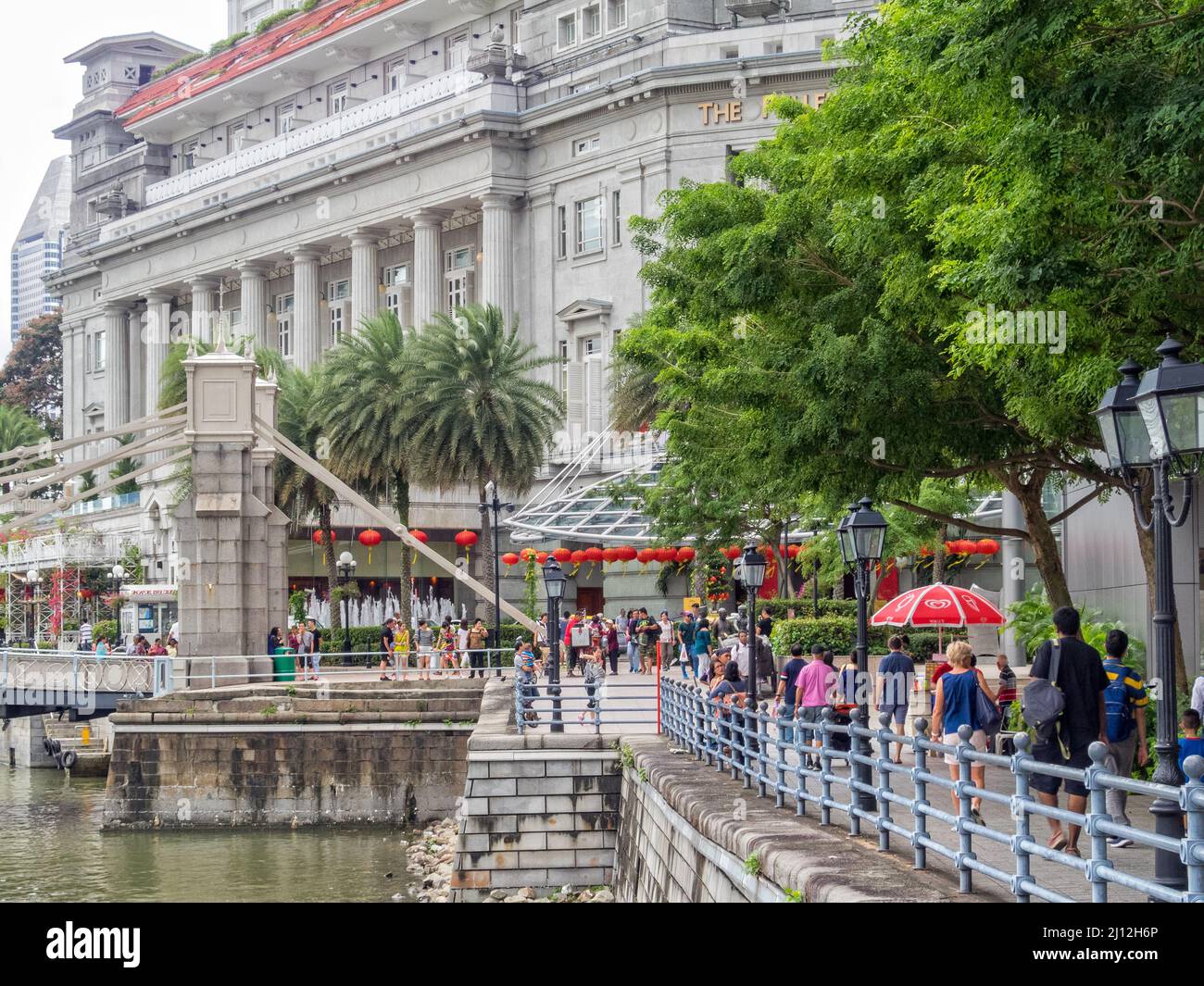 Die Cavenagh Bridge und das Fullerton Hotel am Ende des Boat Quay Walkway - Singapur Stockfoto
