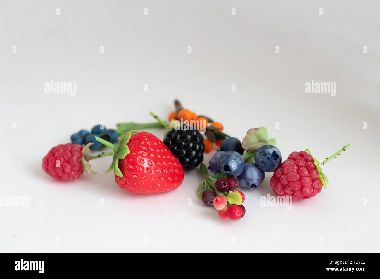 Miniaturfiguren von Erdbeeren, Brombeeren, Himbeeren, Blaubeeren, Heidelbeeren, Preiselbeeren und Preiselbeeren Stockfoto