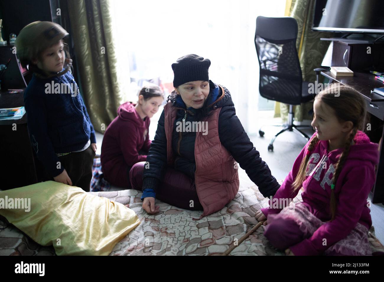 Oksana, die Mutter von Darina, 13 Jahre alt, und Arthur, 7 Jahre alt, in ihren Wohnungen im Erdgeschoss eines Gebäudes, in dem 20 Personen ohne Strom, Wasser oder Gas leben. Die Familie ist Flüchtlinge aus der Region Donbass, sie ist vor 2 Jahren in Irpin angekommen, um ein neues Leben zu beginnen, sie wollen ihr Haus nicht mehr verlassen, auch wenn es überall um sie herum Geschuss gibt. Central Irpin, da die Stadt während der russischen Invasion in der Ukraine am 11. März 2022 unter Beschuss steht. Foto von Raphael Lafargue/ABACAPRESS.COM Stockfoto