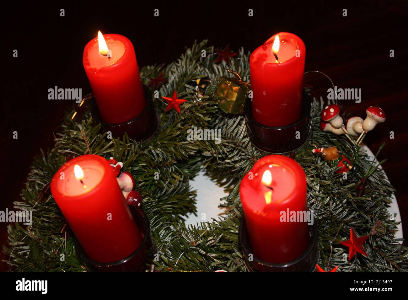Adventskranz am vierten Advent mit 4 brennenden roten Kerzen Stockfoto