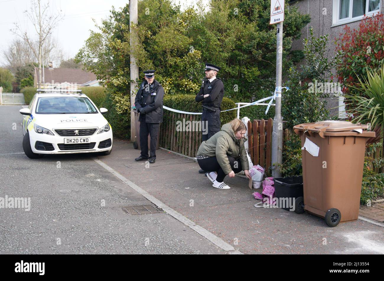 Eine Frau legt Blumen in ein Haus in St. Helens, nachdem ein 17 Monate