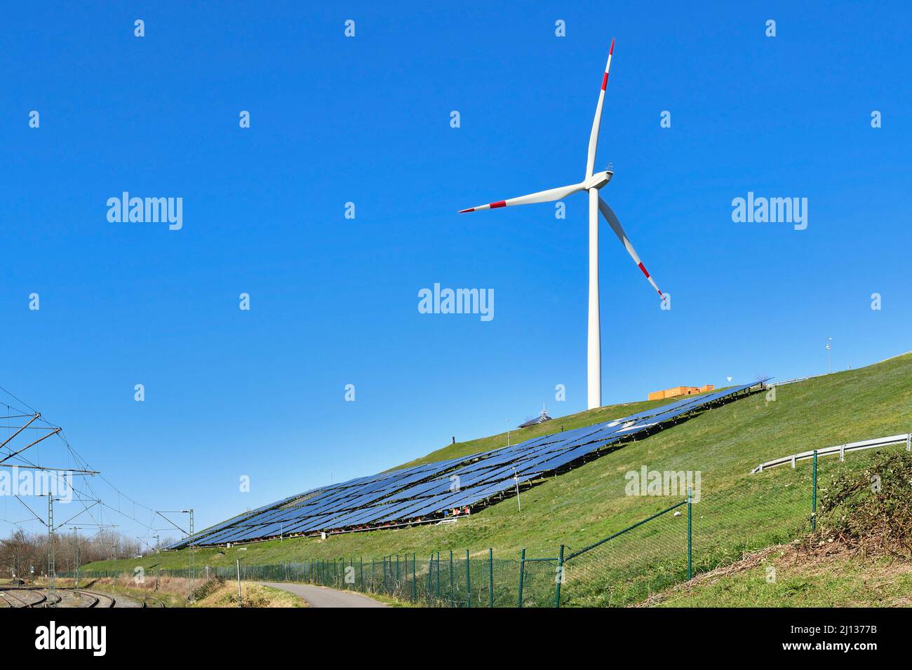 Karlsruhe, Deutschland - Februar 2022: Erneuerbare Wind- und Solarenergie. Windturbine neben der Photovoltaikanlage auf einem Hügel Stockfoto