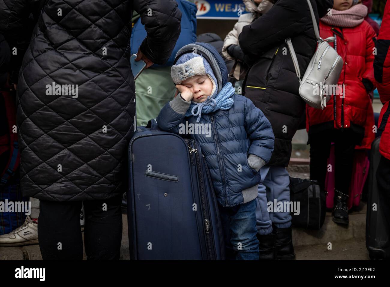 Ankunft von Flüchtlingen aus der Ukraine auf der ukrainischen Seite des Grenzübergangs in Shehyni. Hier warten die Flüchtlinge in langen Warteschlangen auf die Räumung durch ukrainische Grenzbeamte. Nach der Einreise nach Polen werden sie mit warmen Speisen und Kleidung versorgt und dann mit dem Bus zu großen Standorten oder kollektiven Unterkünften gebracht. Stockfoto
