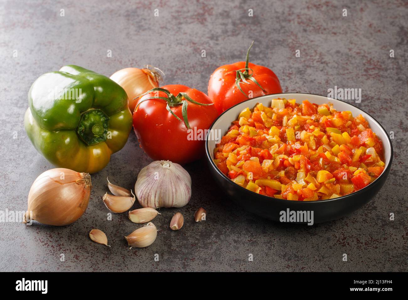 Hausgemachte frische Sofrito-Sauce aus Sommergemüse in einer Schüssel auf dem Tisch. Horizontal Stockfoto