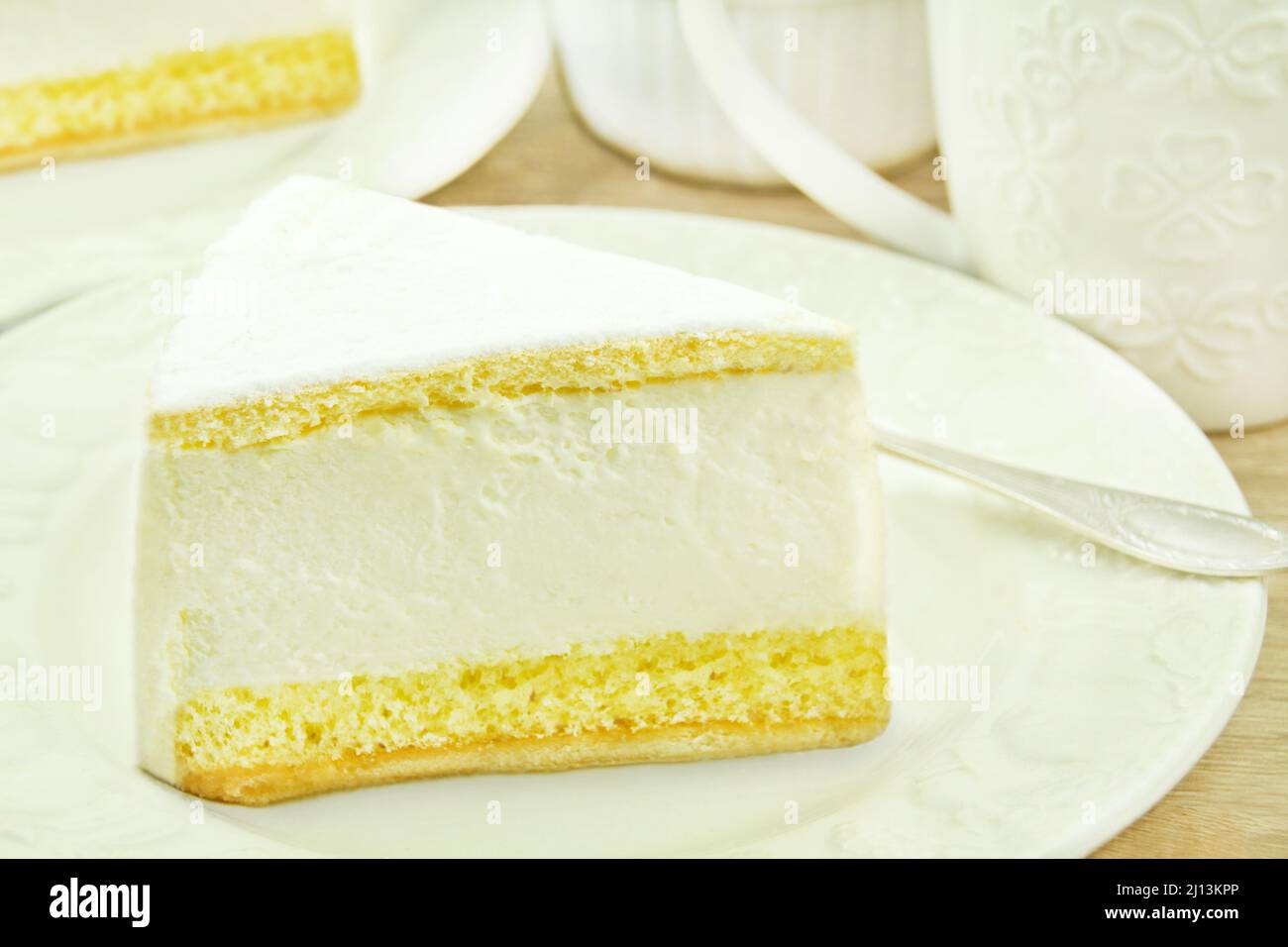 Tischeinstellung mit Frischkäse-Kuchen und Kaffeetassen Stockfoto