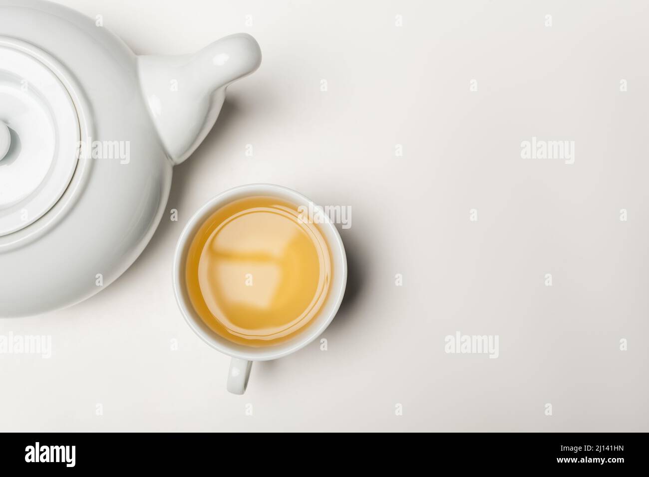 Draufsicht auf eine Tasse Tee und Teekannen auf weißem Hintergrund Stockfoto