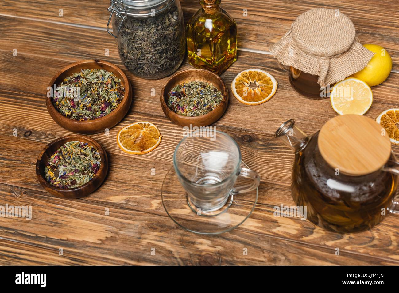 Tasse in der Nähe von Tee, Honig und Schalen auf Holzoberfläche Stockfoto