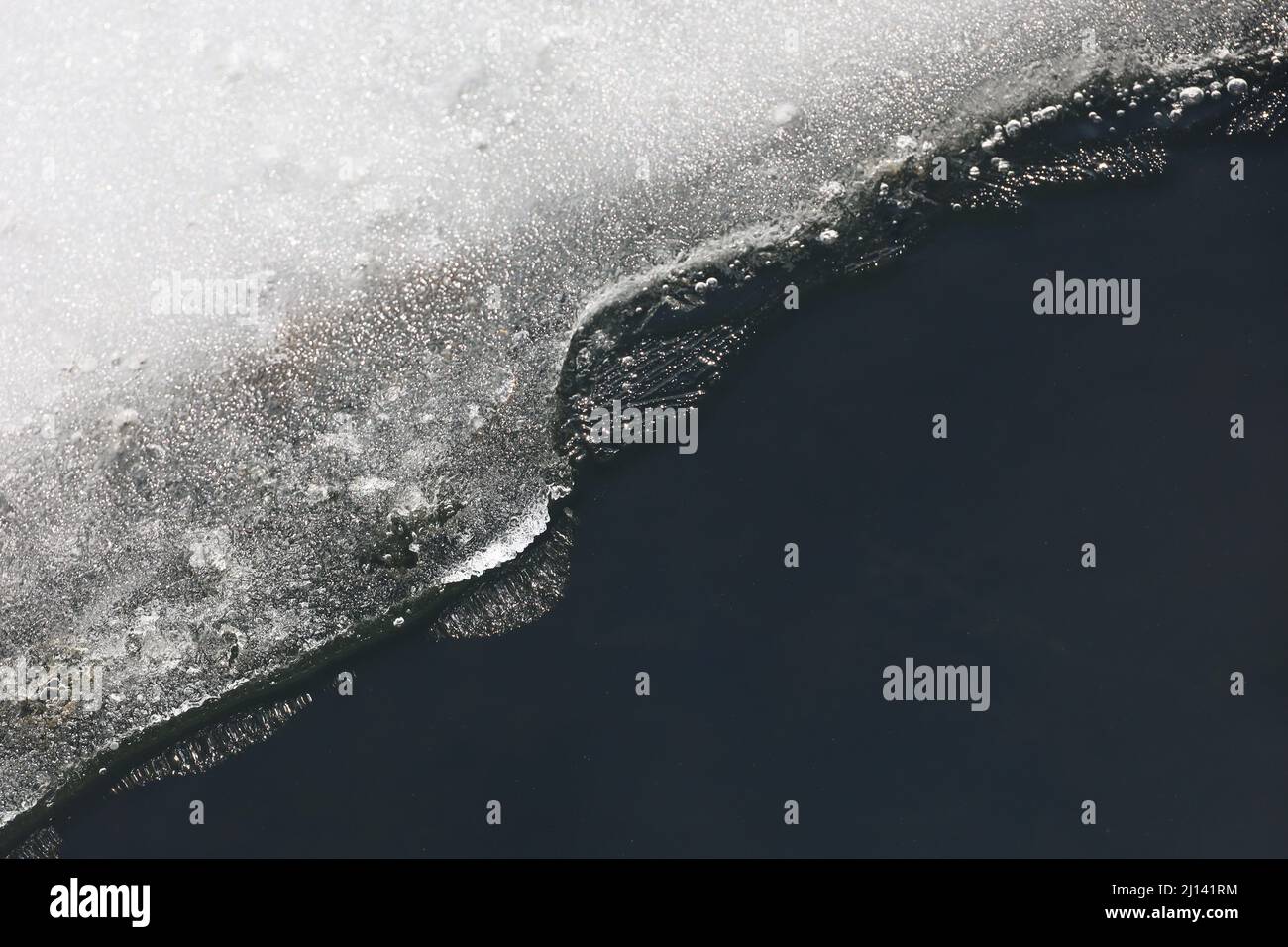 Schmelzendes Eis auf dem See. Eiskante an der gefrorenen Küste, frühe Frühjahrssaison Stockfoto