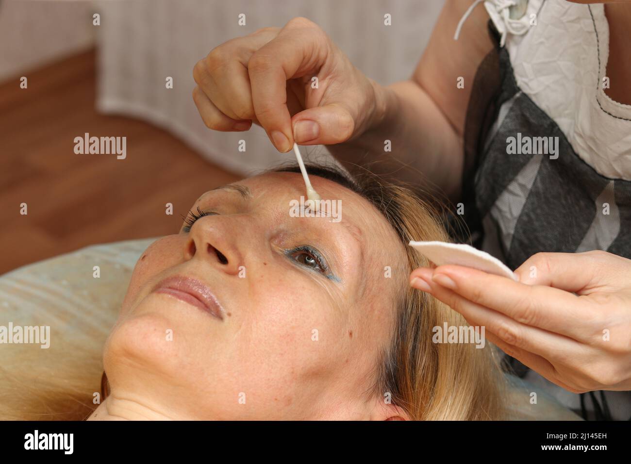 Korrektur und Tönung Henna der Augenbrauen, der Meister wendet sich an die Frau, die auf den Augenbrauen markierend ist Stockfoto