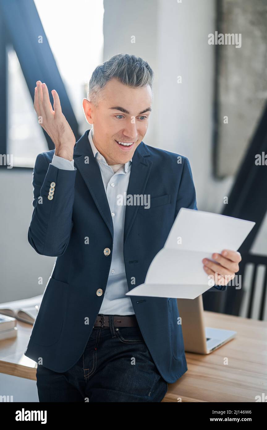 Ein Mann in einem Anzug mit Dokumenten in den Händen Stockfoto