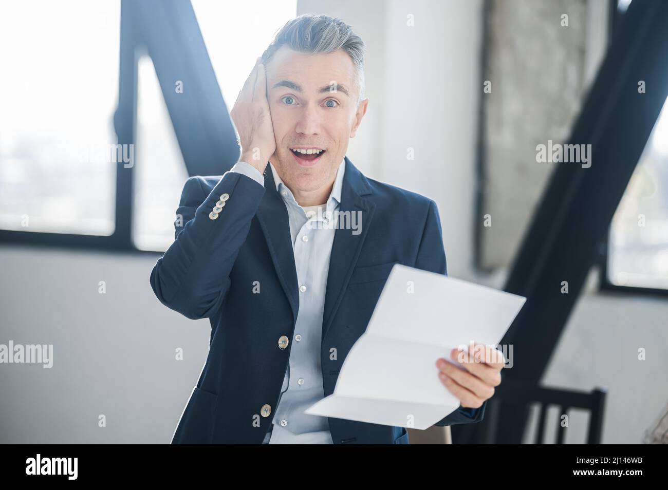 Ein Mann in einem Anzug mit Dokumenten in den Händen Stockfoto