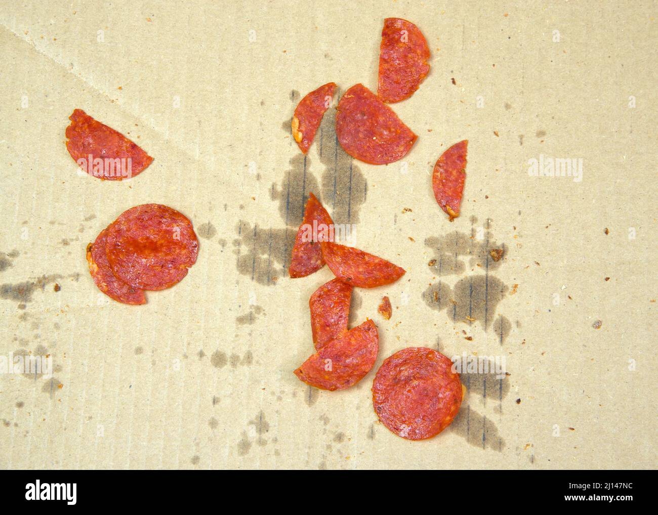 Draufsicht auf Reste von Pepperoni in einer Lieferkiste, nachdem die Pizza vollständig verzehrt wurde. Stockfoto