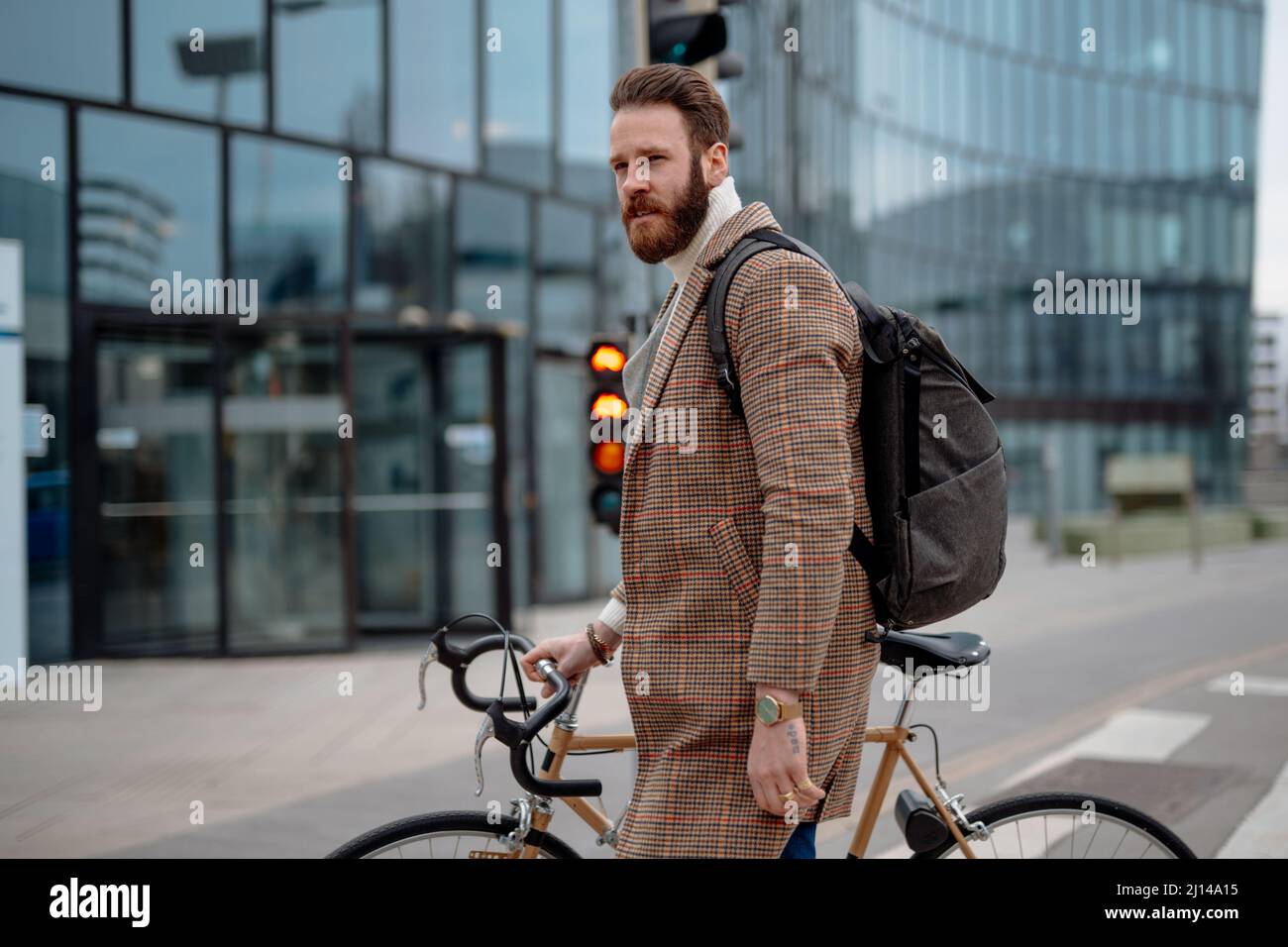Geschäftsmann mit Fahrrad auf dem Weg zur Arbeit. Pendeln zur Arbeit. Männlicher Manager im Business Center. Öko-Reisen Stockfoto