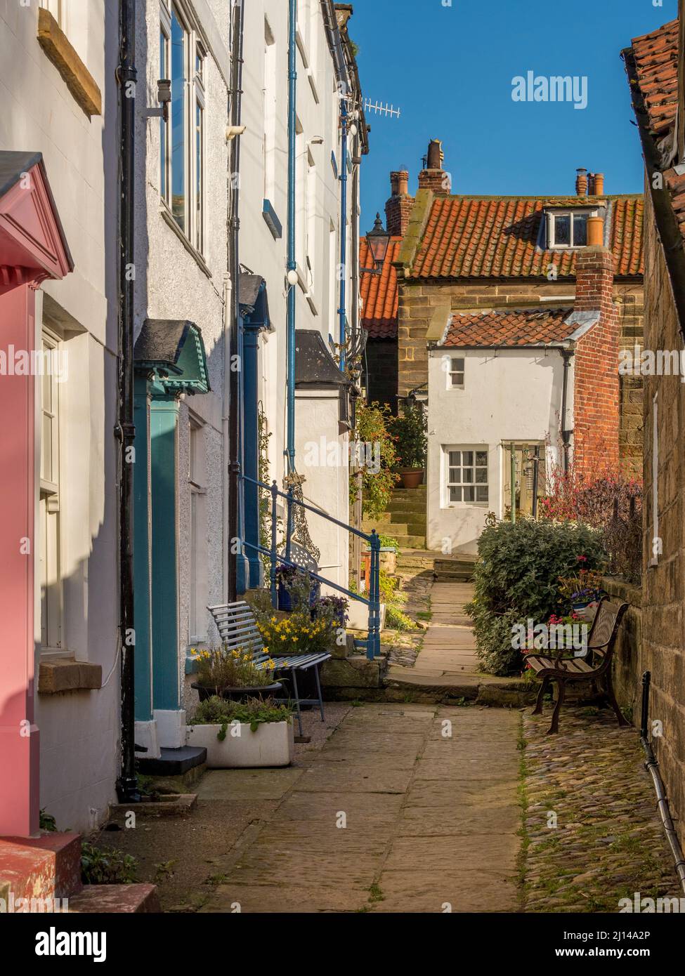 Traditionelle, weiß gerenderte Küstenhütten an einer schmalen Gasse in Robin Hood's Bay, North Yorkshire. VEREINIGTES KÖNIGREICH Stockfoto