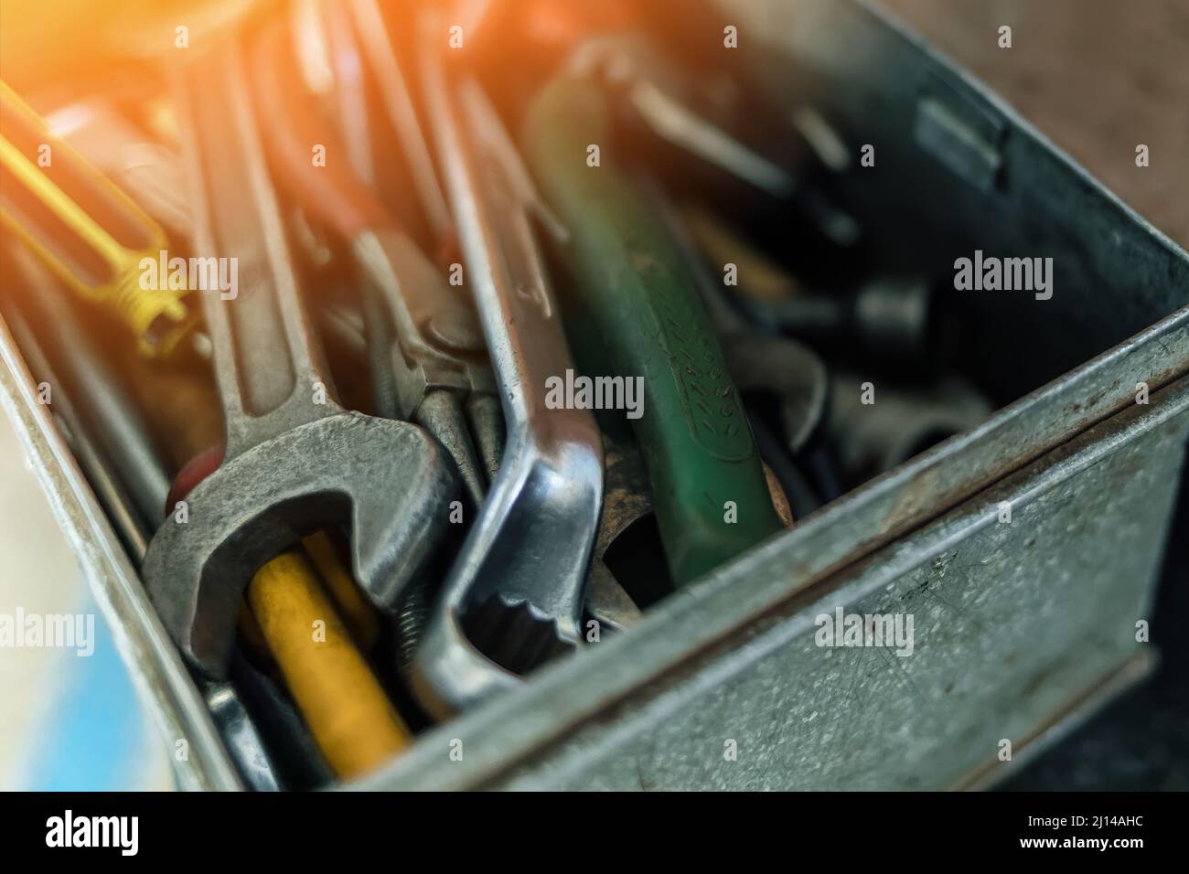 Metallbox mit Schraubenschlüsseln und Schraubendrehern in Nahaufnahme. Arbeitswerkzeug des Schlossermeisters oder Mechanikers. Blendung durch Sonnenlicht. Hintergrund. Stockfoto