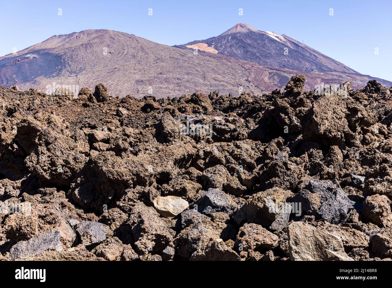 Zerklüftete vulkanische Landschaft eines erstarrten Lavastroms mit Blick auf den Pico Viejo und den Teide im Nationalpark Las Canadas del Teide, Teneriffa Stockfoto