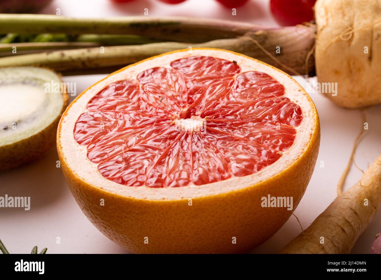 Die Nahaufnahme von frischer Grapefruit halbierte sich zwischen verschiedenen Speisen auf dem Tisch Stockfoto