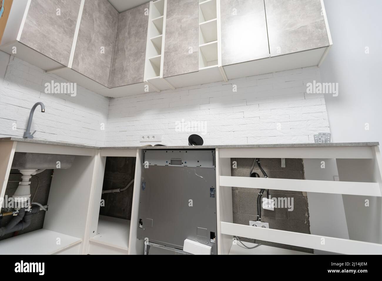 Installationsschläuche für Geschirrspüler Maschine häusliche Verbindung Rohrleitungen in der Küche Stockfoto