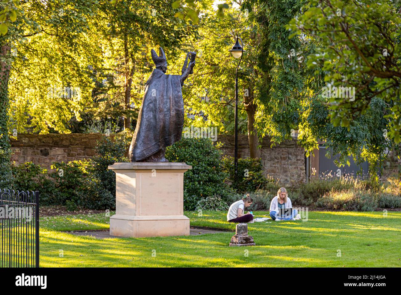 Die Statue von Bischof Henry Wardlaw, der zwei Studentinnen im St Marys College Quadrangle, University of St Andrews, Fife, Schottland, beobachtet Stockfoto