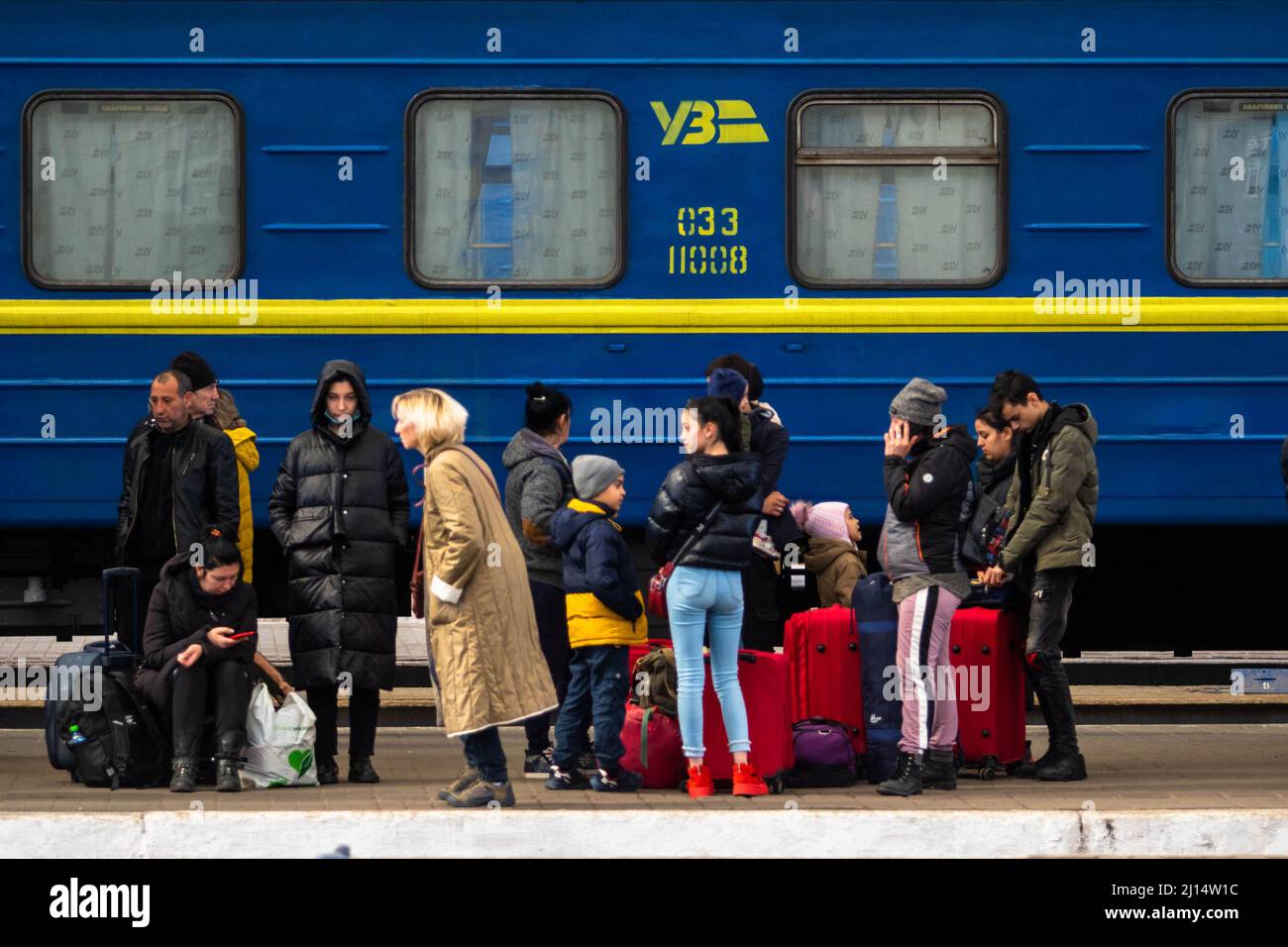 Lwiw, Oblast Lwiw, Ukraine. 22. März 2022. Vertriebene warten neben einem blau-gelben ukrainischen Zug. Während der Krieg in der Ukraine andauert, fliehen die Menschen vor der Gewalt mit dem Zug, der nach Lemberg kommt oder nach Polen weiterfährt. (Bild: © Ty Oneil/SOPA Images via ZUMA Press Wire) Stockfoto