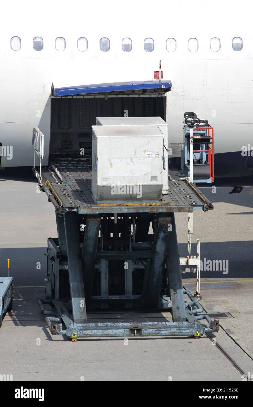 Ladegeräte werden am internationalen Flughafen in das Flugzeug geladen Stockfoto