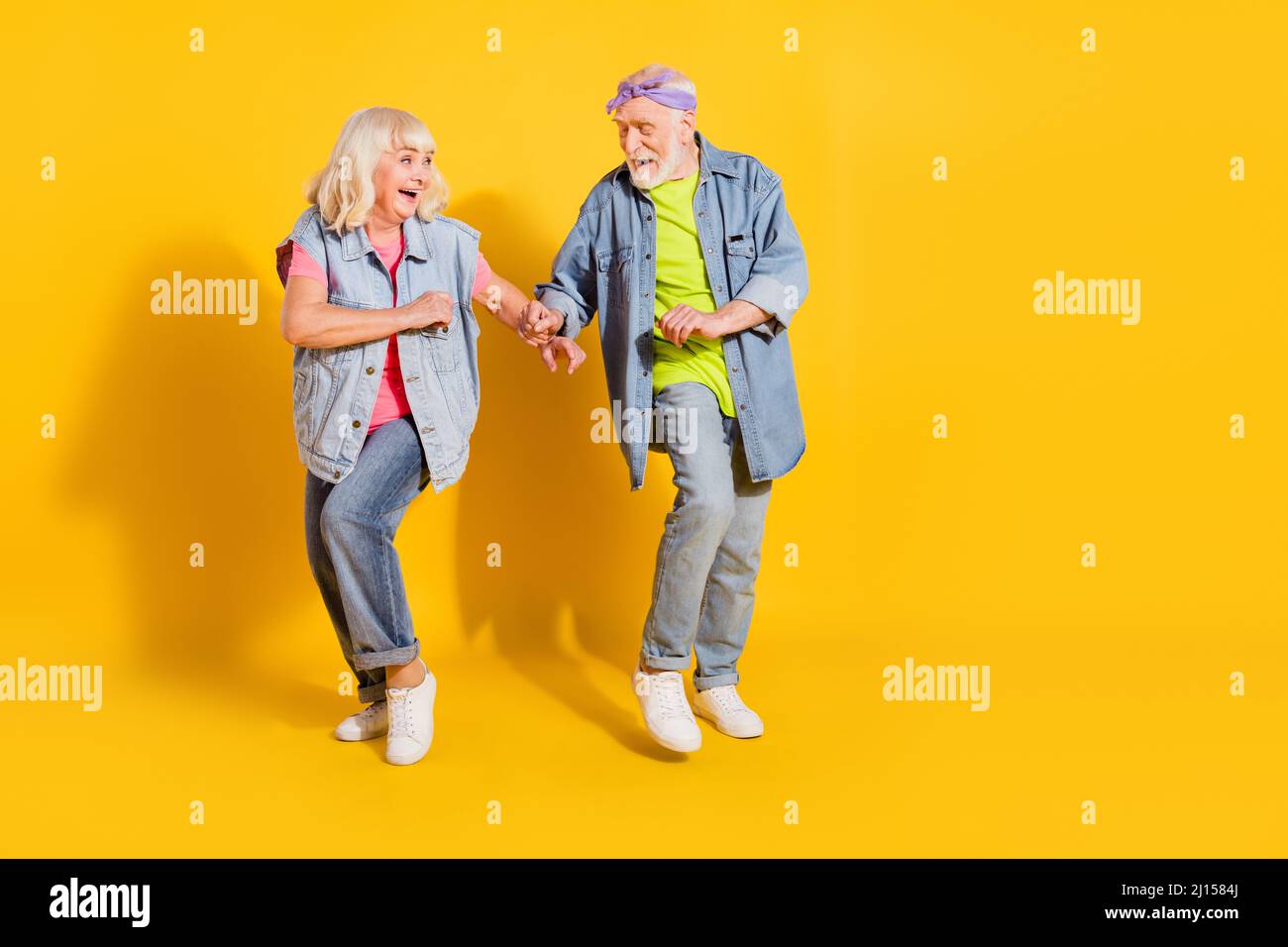 Foto von süßen liebenswert Mann Frau tragen Jeans Hemden tanzen leeren Raum isoliert gelbe Farbe Hintergrund Stockfoto