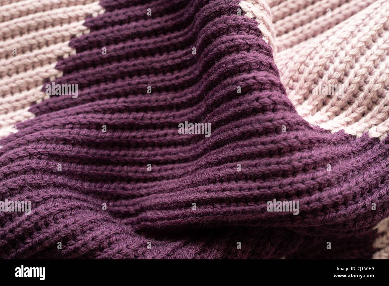 Nahaufnahme des Strickschals aus violetter Wolle im Hintergrund Stockfoto