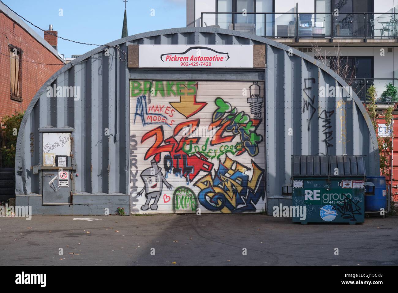 Verschiedene Graffitis am Garagentor der Kfz-Werkstatt Stockfoto