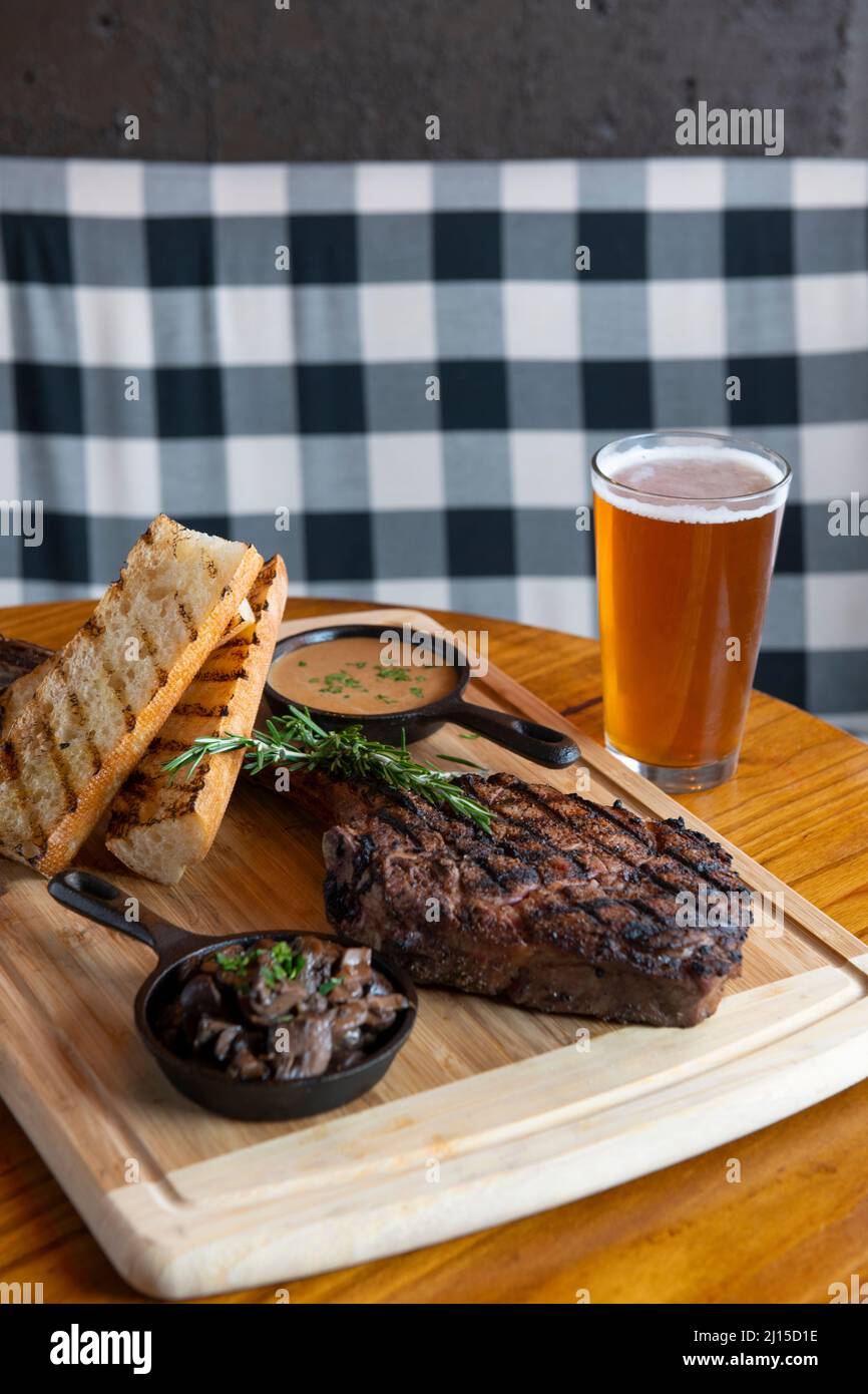 Essen Tomahawk Steak - Ribeye - mit Pilzsoße und Brot mit Bier vom Fass in einem Pub in Arlington Virginia namens The Pinemoor Stockfoto