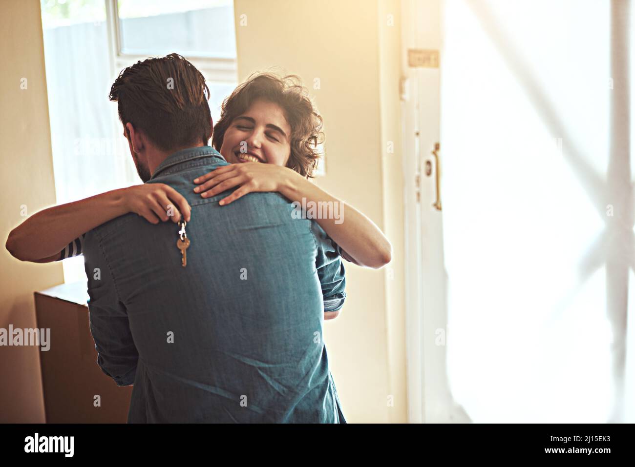 Vergessen Sie die Schlüssel zum Haus, die Schlüssel zu einem Traum. Aufnahme eines glücklichen jungen Paares, das sich umarmt, als sie in ihr neues Zuhause ziehen. Stockfoto