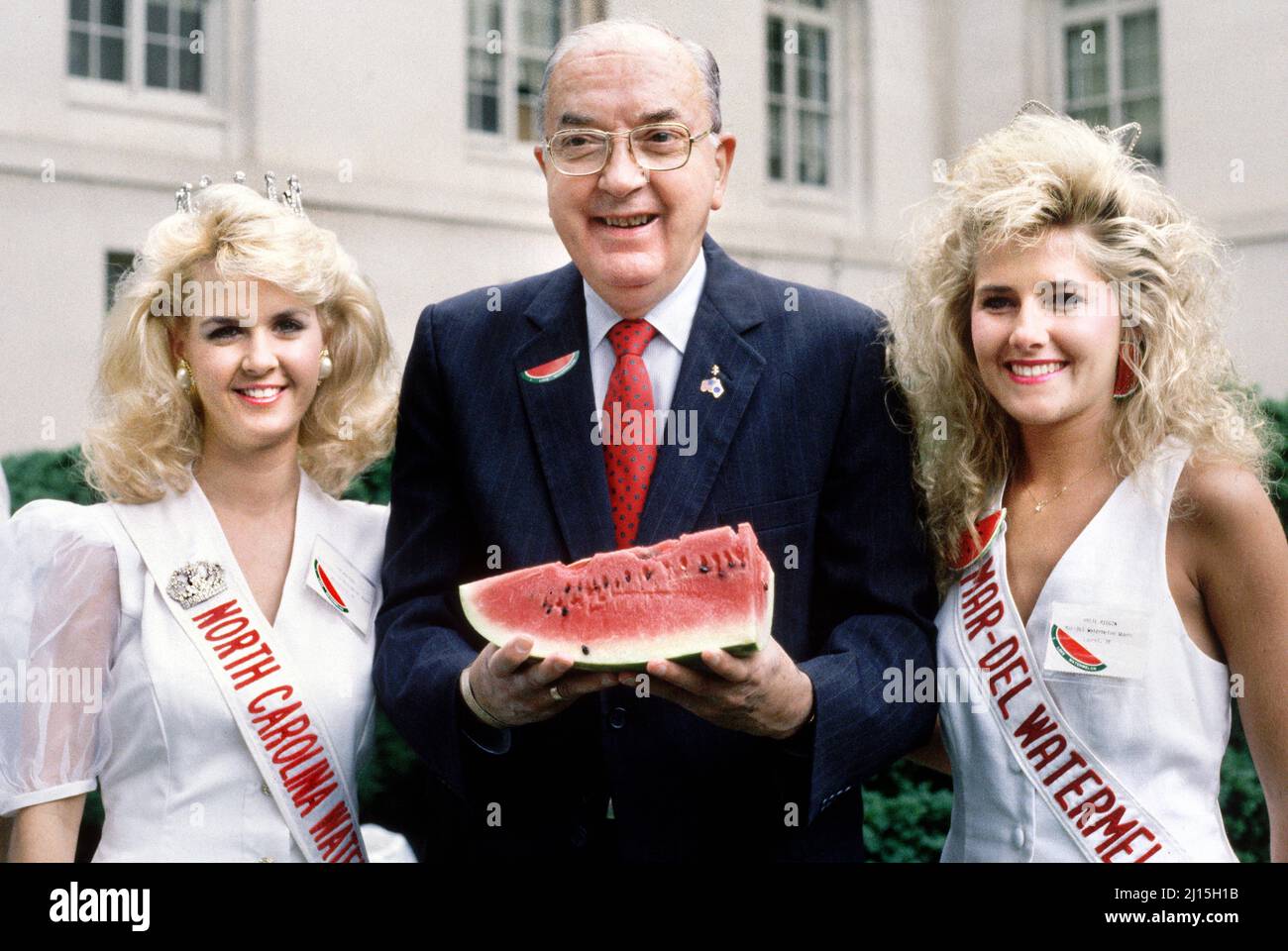 North Carolina Jesse Helms hält Wassermelone und steht zwischen zwei Schönheitswettbewerbern bei einer Veranstaltung, die von der National Watermelon Association, Washington DC, USA, gesponsert wird, Laura Patterson, Roll Call Photograph Collection, Juli 1991 Stockfoto
