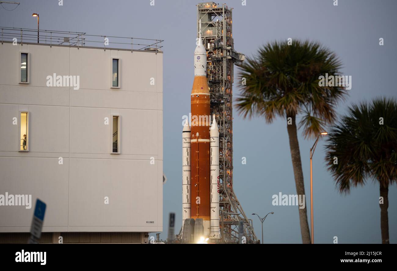 Die NASA-Rakete Space Launch System (SLS) mit der Orion-Sonde an Bord ist auf einem mobilen Trägerrakete zu sehen, während sie am Rocco A. Petrone Launch Control Center auf dem Weg zum Launch Complex 39B zum ersten Mal vorbeirollt, am Donnerstag, den 17. März 2022, im Kennedy Space Center der NASA in Florida. Vor dem Artemis I-Flugtest der NASA werden die vollständig gestapelte und integrierte SLS-Rakete und die Orion-Raumsonde im Launch Complex 39B einer Nassprobe unterzogen, um die Systeme zu verifizieren und Countdown-Verfahren für den ersten Start zu üben. Foto: (NASA/Joel Kowsky) Stockfoto