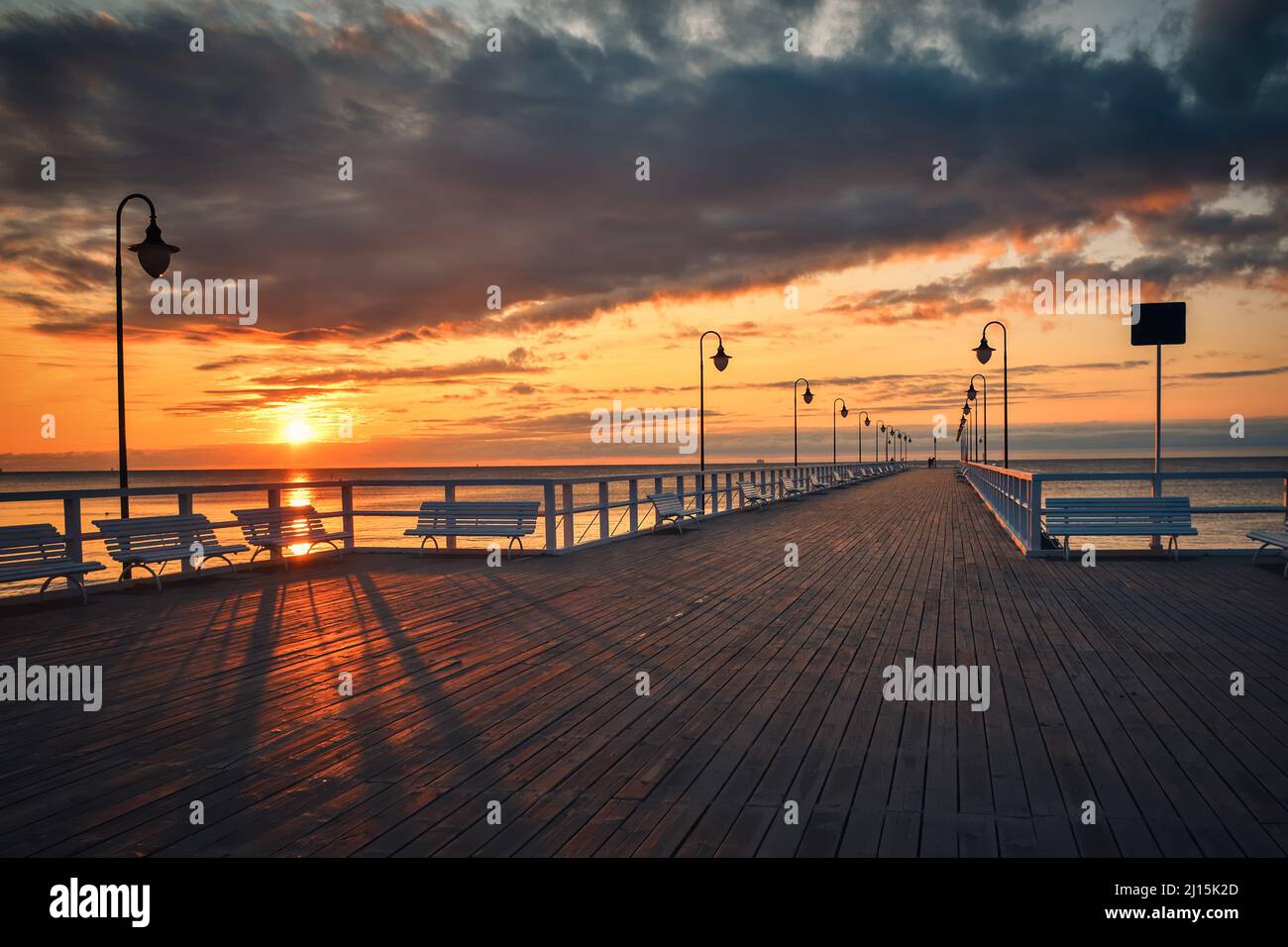 Wunderschöne Landschaft am Morgen am Meer. Hölzerner Pier mit einem bunten Himmel in Gdynia Orlowo, Polen. Stockfoto