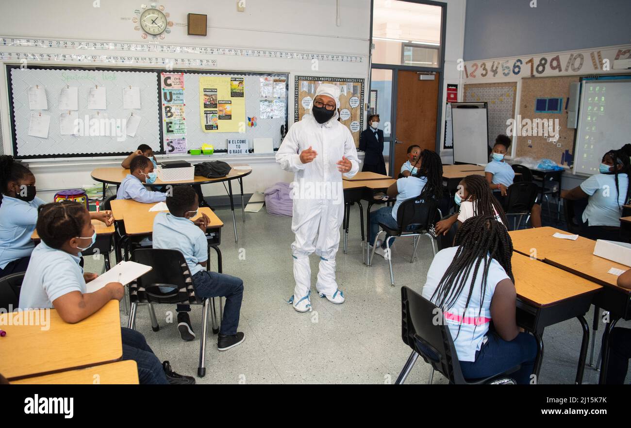 Kenneth Harris II, ein Ingenieur am Goddard Space Flight Center der NASA, wird in einem „Hasenanzug“ gesehen, als er mit Studenten über die Arbeit in einem Reinraum spricht, Donnerstag, den 18. November 2021, an der Garfield Elementary School in Washington, DC. Foto: (NASA/Joel Kowsky) Stockfoto