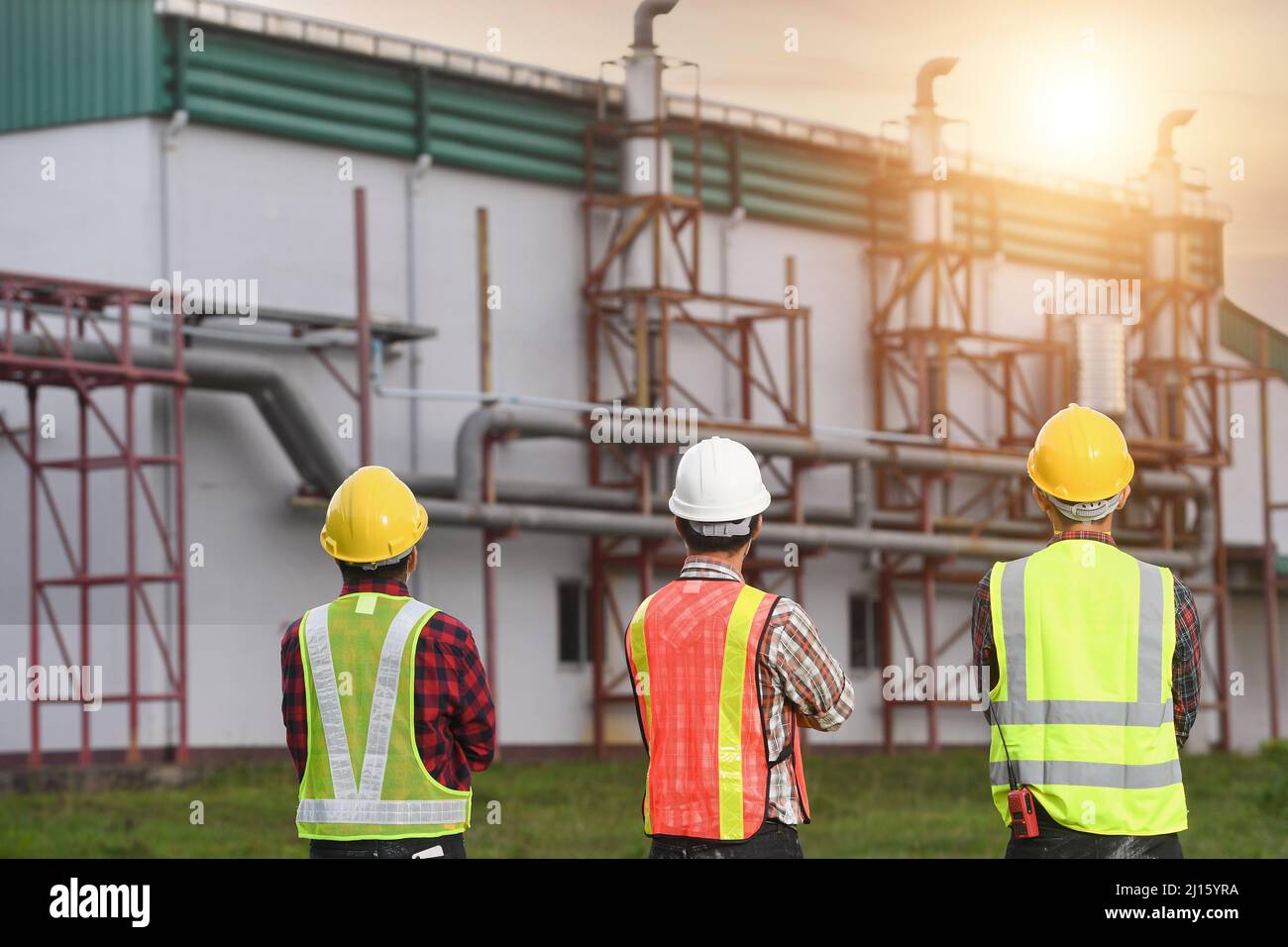 Ingenieur diskutiert technische Dokumentation mit seiner Hilfe auf dem Gebiet einer modernen Anlage.Ingenieure arbeiten im Kraftwerksbereich Stockfoto