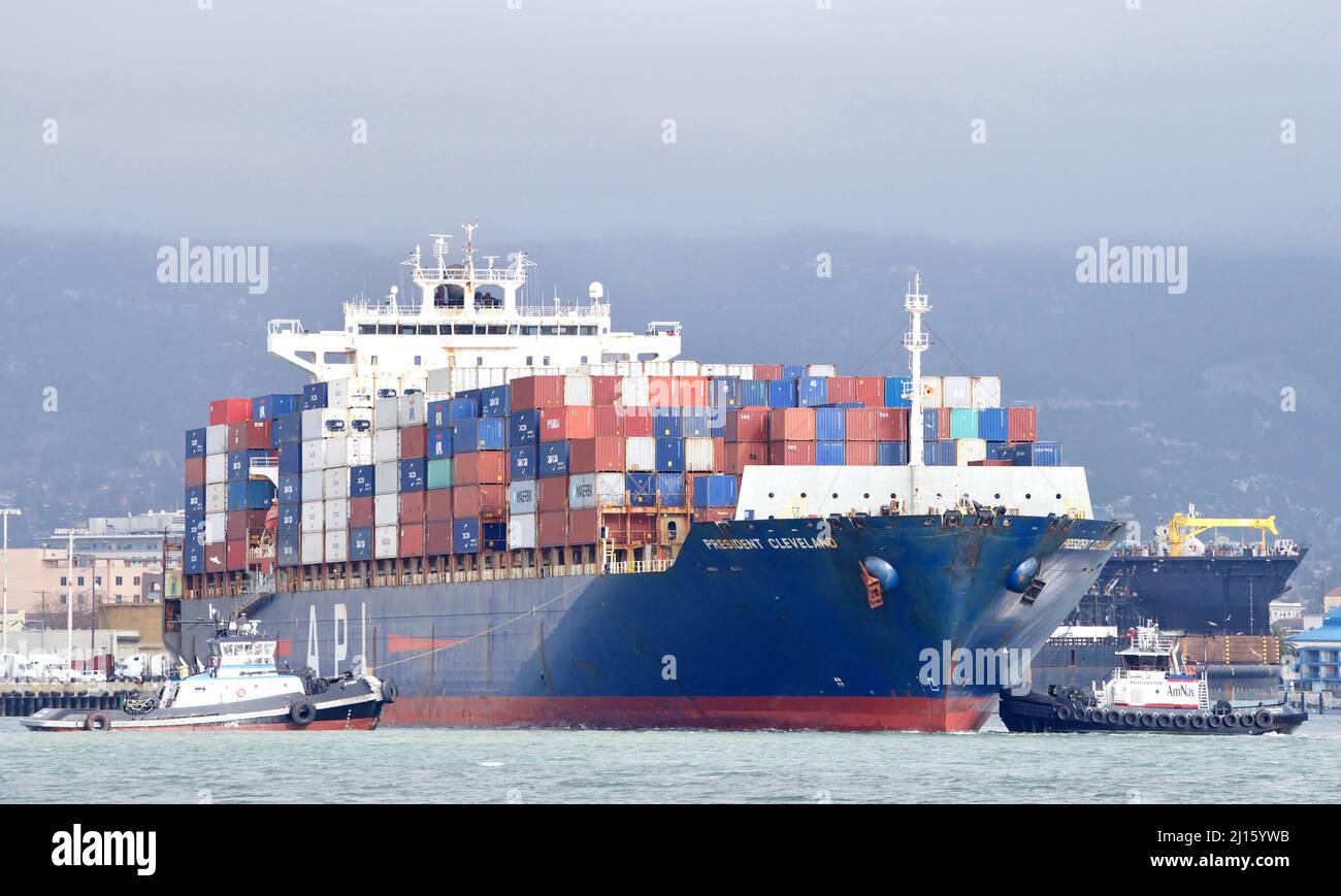 Oakland, CA - 14. Feb 2022: Schlepper Z-FOUR und REVOLUTION unterstützen APL Frachtschiff PRÄSIDENT CLEVELAND, sich vor dem Andocken am Po um 180 Grad zu drehen Stockfoto