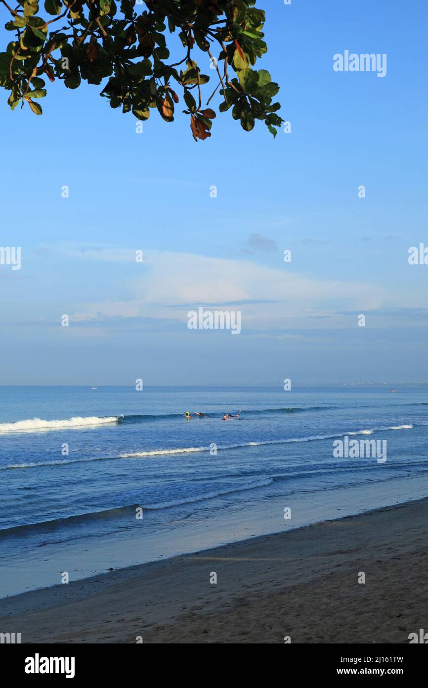 Am frühen Morgen am Kuta Beach in Bali, Indonesien mit einem weißen Sandstrand, kleinen Wellen und nur ein paar Menschen aufgrund der Pandemie. Stockfoto