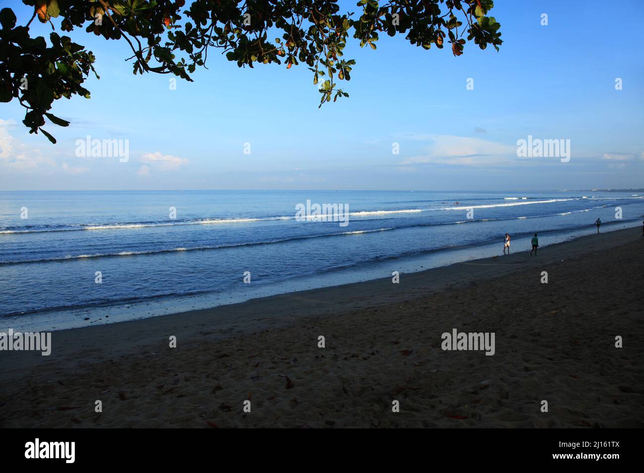Am frühen Morgen am Kuta Beach in Bali, Indonesien mit einem weißen Sandstrand, kleinen Wellen und nur ein paar Menschen aufgrund der Pandemie. Stockfoto