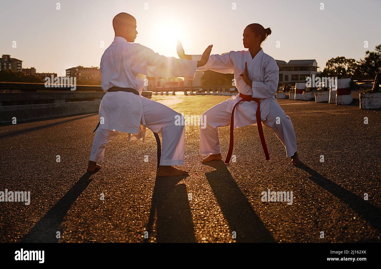 Bereit zum Spar. Zwei Sportler stehen sich gegenüber und üben ihr Karate, während sie GI tragen. Stockfoto