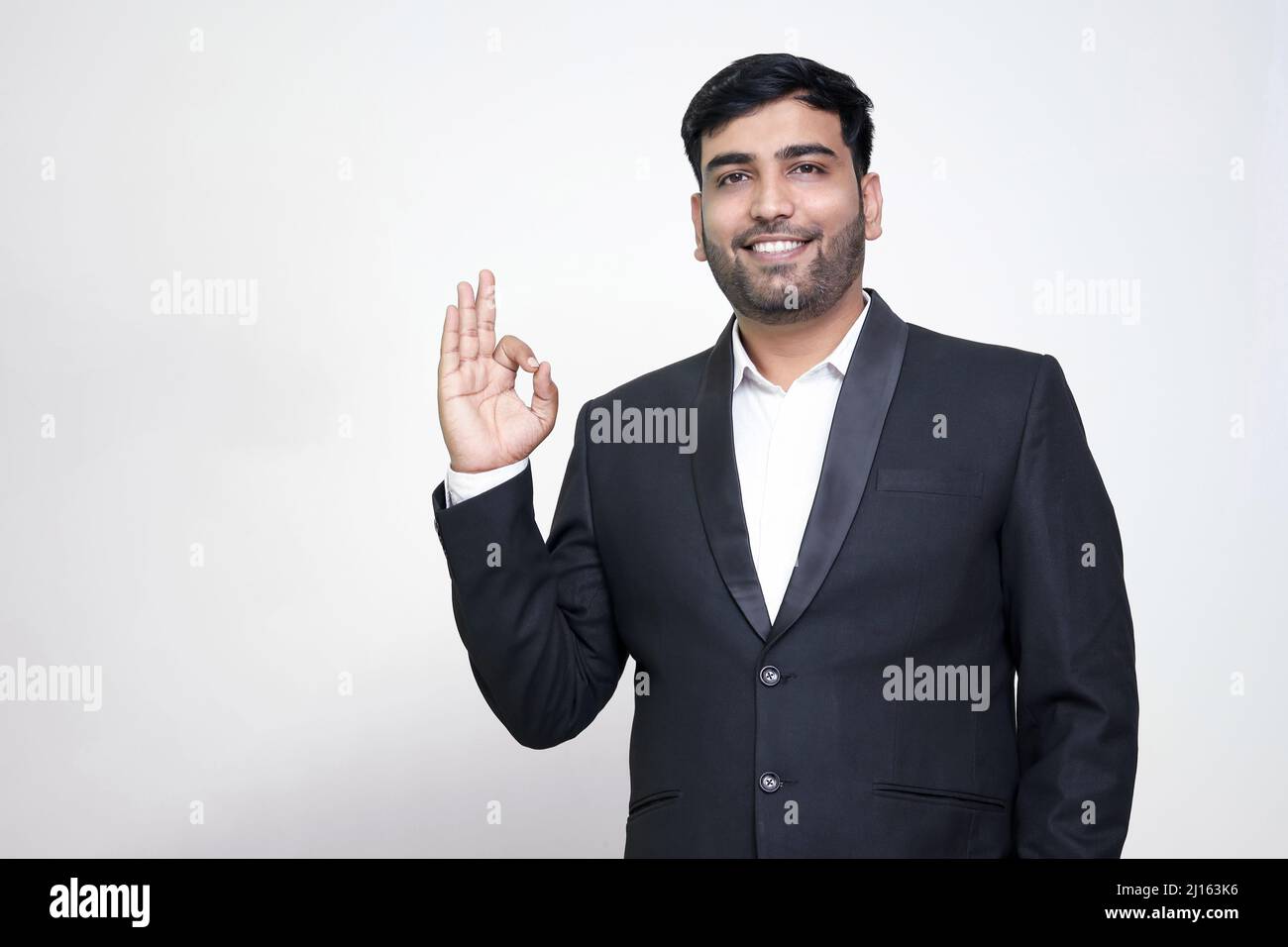 Porträt eines fröhlichen jungen Mannes, der eine gute Geste auf dem weißen, isolierten Hintergrund zeigt. Stockfoto