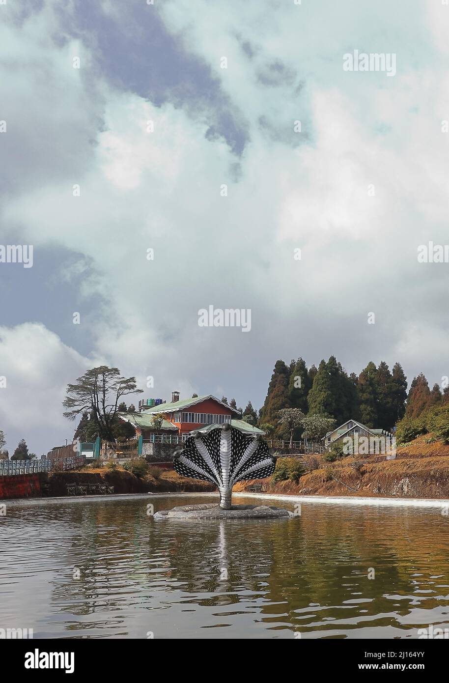 Geheimer jore pokhari See, umgeben von Kiefernwald und mythologischer Schlangenstatue in der Mitte des Sees in der Nähe der darjeeling Bergstation in westbengalen Stockfoto