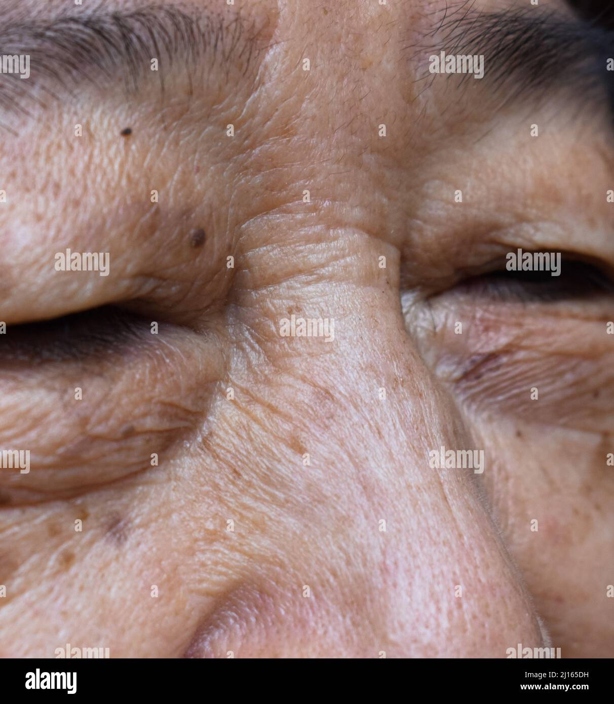 Falten im Gesicht der älteren südostasiatischen Frau. Nahaufnahme. Stockfoto