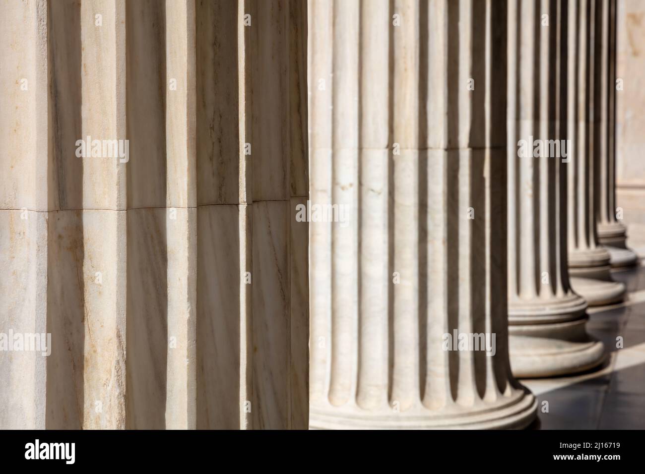 Säulen in einer Reihe. Klassische Säulen aus weißem Marmor, Justizgebäude, Kolonnade am Eingang des Gerichts, Nahaufnahme Stockfoto