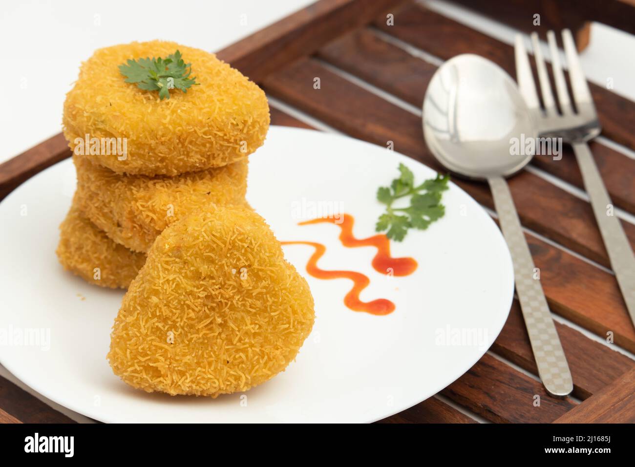 Herzform Veg Paneer Cutlet Tikki mit Bhujia Sev Beschichtung aus indischem Hüttenkäse zerbröckelte Panir Gewürze Maida Grünes Gemüse wie Karotte, B Stockfoto