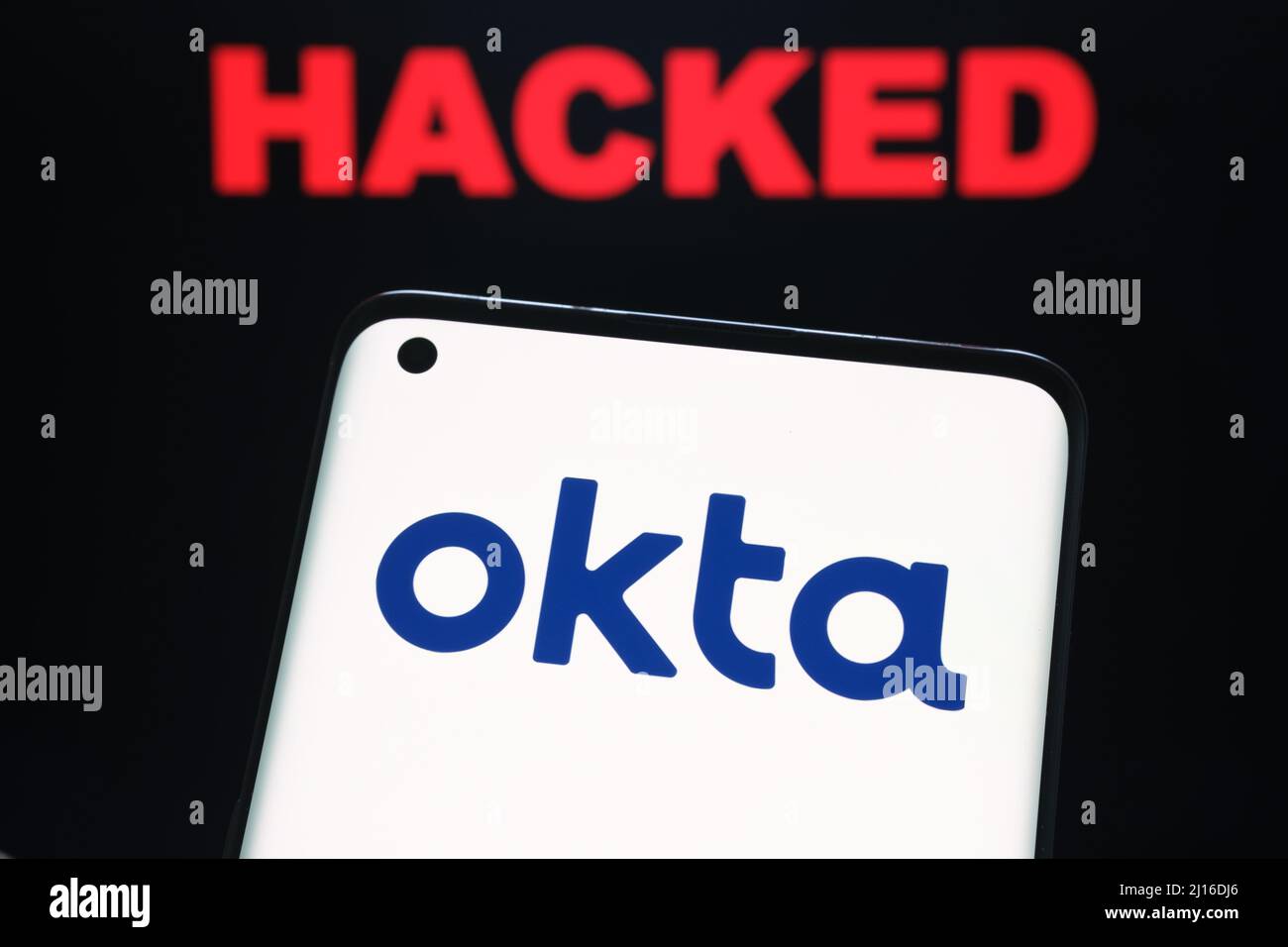 Okta Sicherheit Firma Logo auf dem Smartphone und das Wort GEHACKT auf verschwommenem Hintergrund gesehen. Konzept für Hack. Stafford, Großbritannien, 22. März 2022. Stockfoto