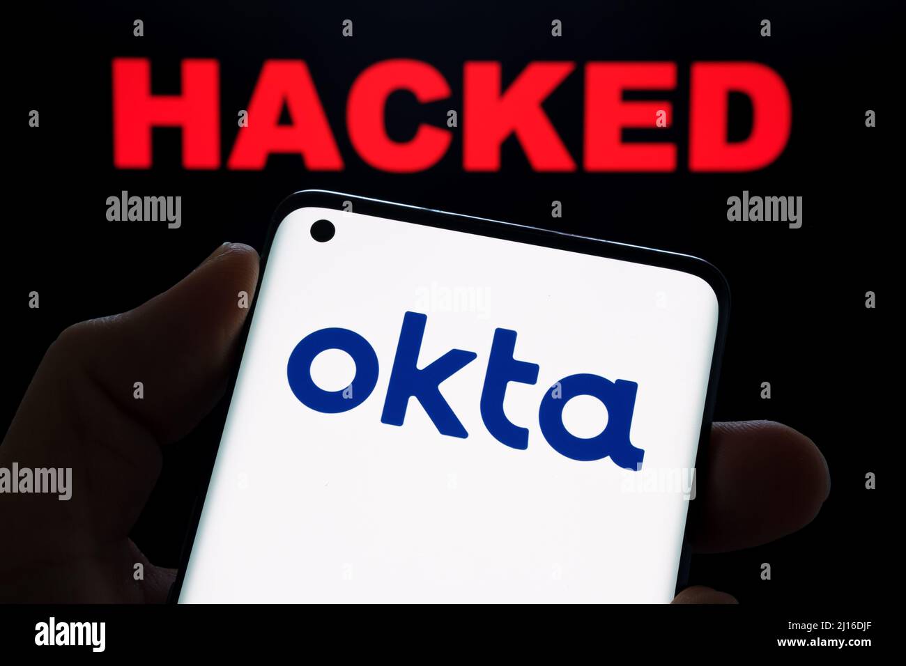 Okta Sicherheit Firma Logo auf dem Smartphone und das Wort GEHACKT auf verschwommenem Hintergrund gesehen. Konzept für Hack. Stafford, Großbritannien, 22. März 2022. Stockfoto